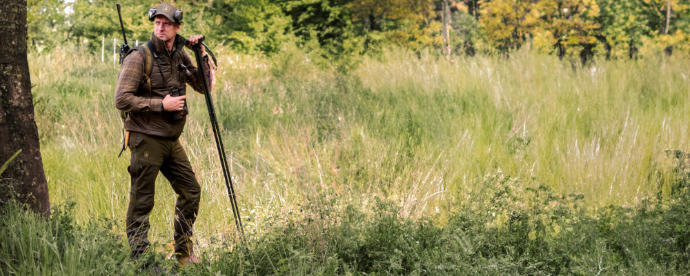 SPODNIE DEERHUNTER STRIKE 3985 - Głęboka Zieleń - Pozowanie na tle lasu z pastorałem